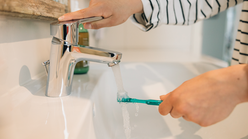 Toothbrush under a running tap