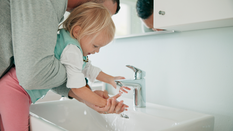 Father and daughter washing hands in the bathroom