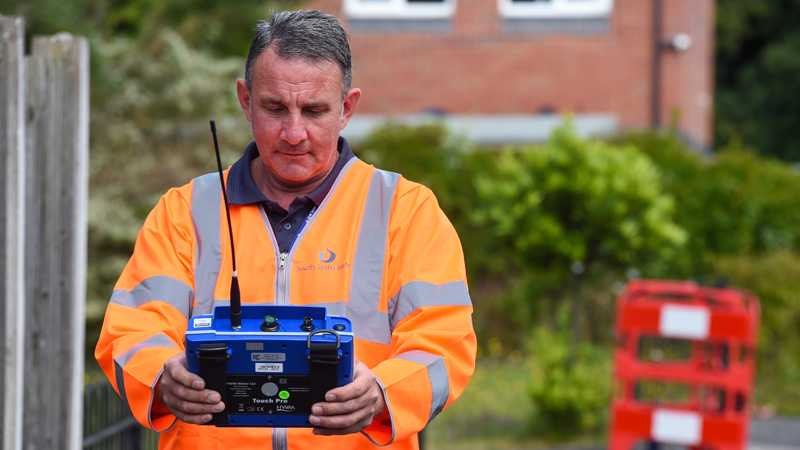 Leakage technician using an electronic device to detect leaks